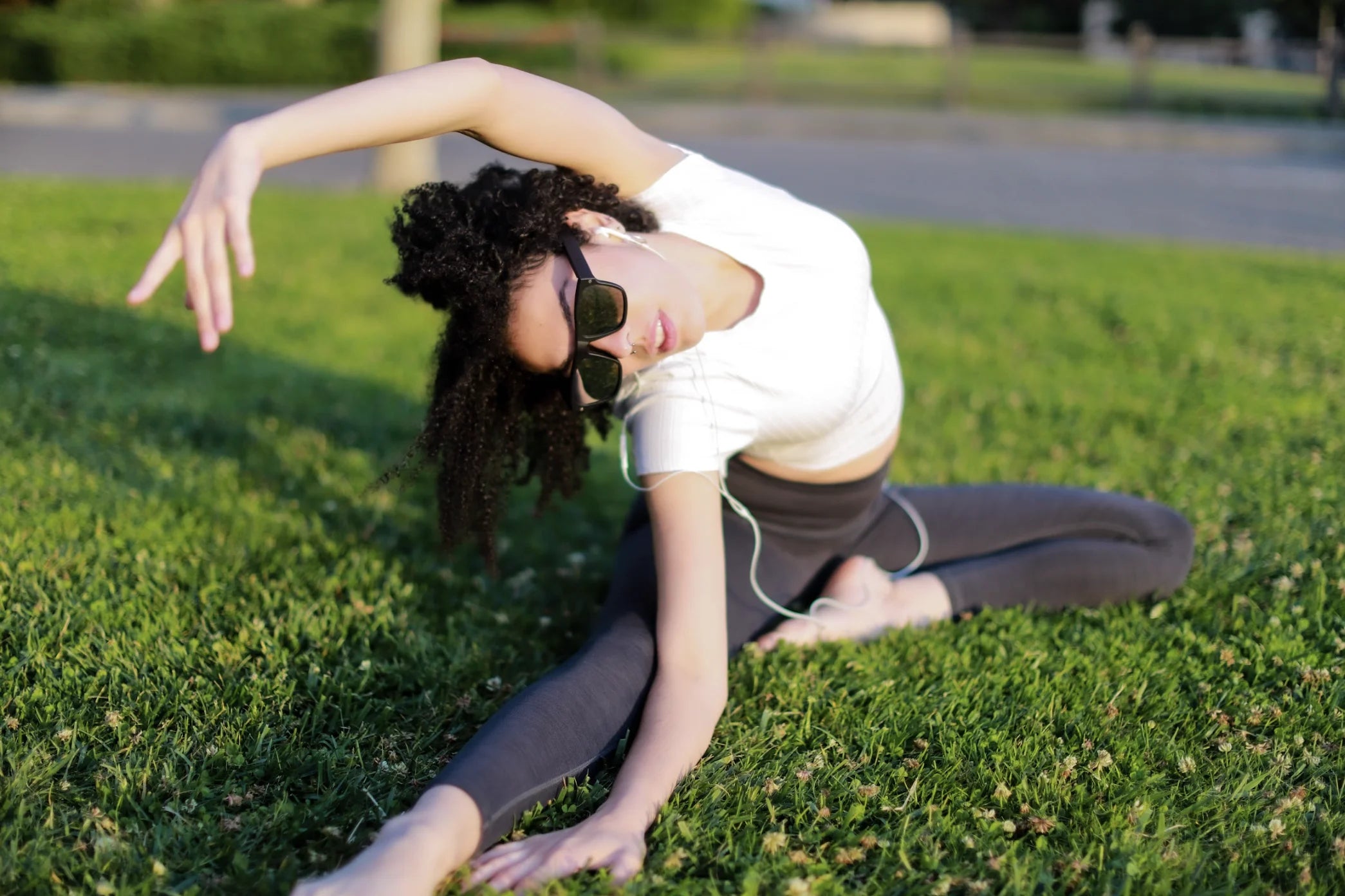 Woman doing yoga while wearing Healyan Glasses and listening to music